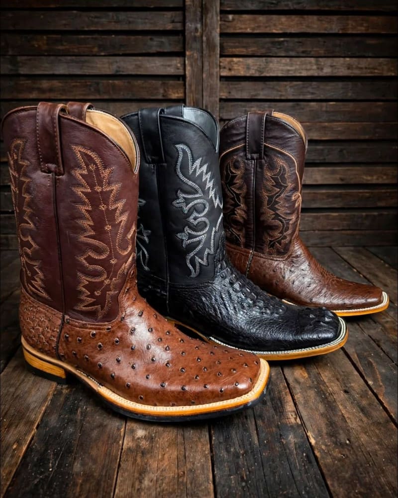 Botas de avestruz en café y negro sobre madera